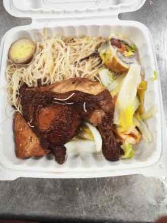 Chicken leg with rice noodles Takeout box with a braised chicken leg, thin rice noodles, half a braised egg, fried tofu, stewed napa cabbage and a sliced egg roll