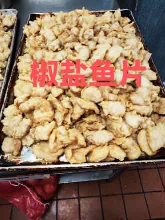 Sheet tray heaped with lightly battered deep-fried white fish fillet pieces fresh from the fryer
