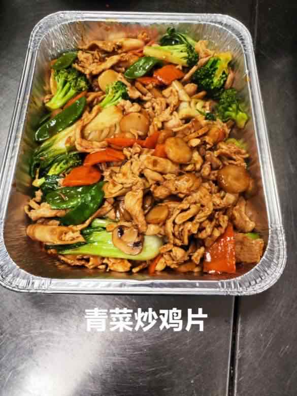 Catering tray of sliced chicken with baby bok choy, mushrooms and red bell pepper in brown sauce