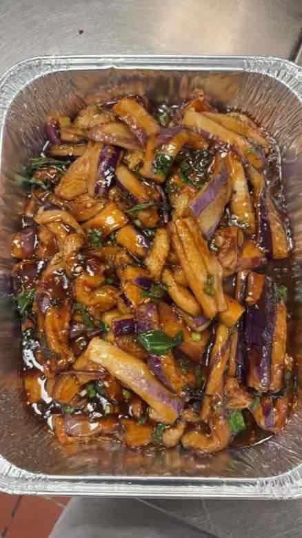 Eggplant catering tray Catering tray of braised eggplant batons in a glossy dark garlic sauce with chopped scallion
