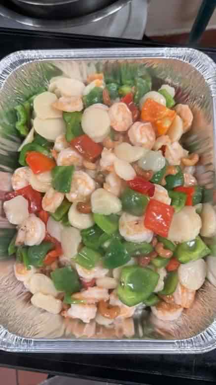 Seafood catering tray Catering tray of shrimp and scallops stir-fried with green and red bell pepper and carrot in a light sauce