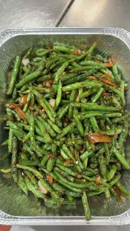 Catering tray of dry-sauteed string beans with garlic, minced onion and red chili